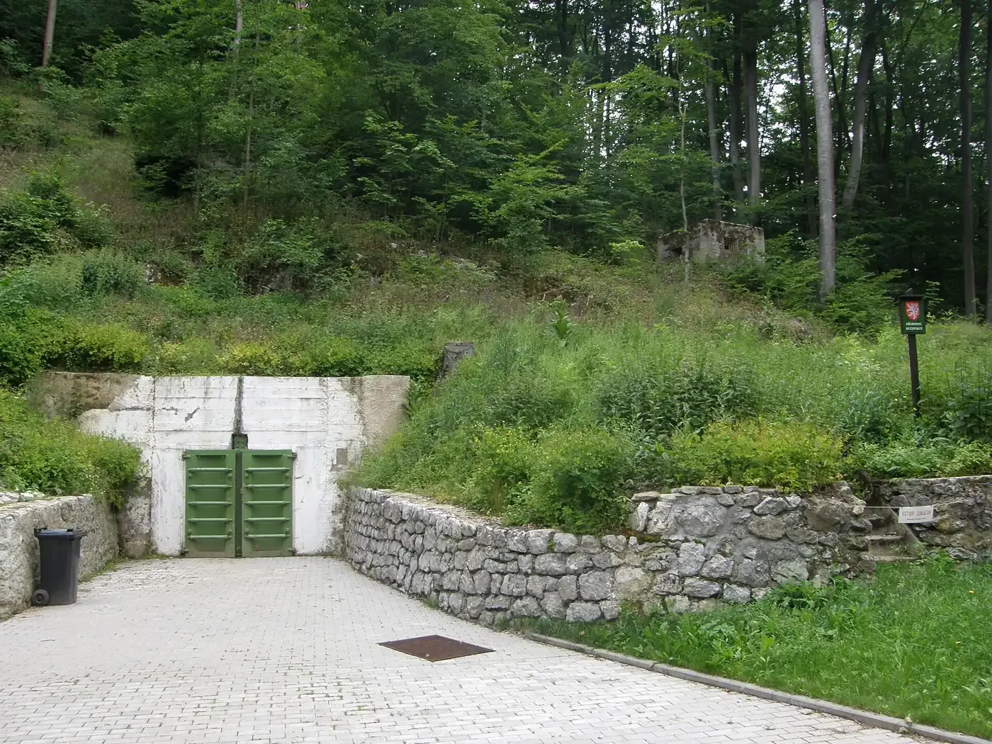 Eingang zur Höhle Výpustek mit dem grünen Tor der ehemaligen Militäranlage